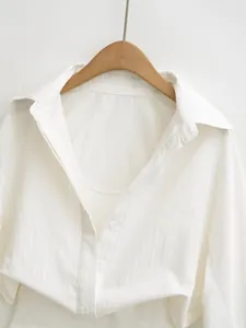 Detailed macro shot of white textured long-sleeve bodysuit shirt with button closure