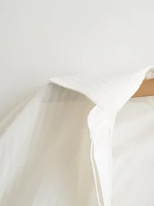 Detailed close-up showing the elegant collar and fine texture of a white striped shirt bodysuit.