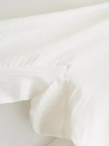 Detailed close-up showing the fine vertical stripes and stitching on a white shirt bodysuit