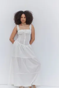 Detalle de vestido largo blanco con volantes, frente abotonado y tirantes