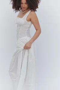 Detalle de un vestido largo bohemio blanco con volantes y diseño de botones frontales