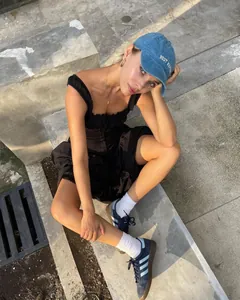 Detalle de un vestido largo negro con volantes llevado por una modelo en exteriores