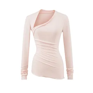 Détail d'un haut rose à manches longues et col asymétrique avec texture froncée