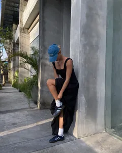 Detalle de un elegante vestido largo de verano negro con volantes usado por una modelo al aire libre