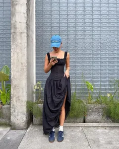 Foto de estilo de vida de un elegante vestido largo negro con volantes y botones delante