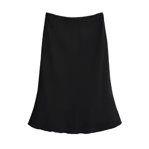Vue détaillée du tissu noir lisse et de l'ourlet en ligne A de la jupe mi-longue