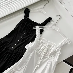 Detalle de un vestido largo estilo resort con tirantes rizados y botones