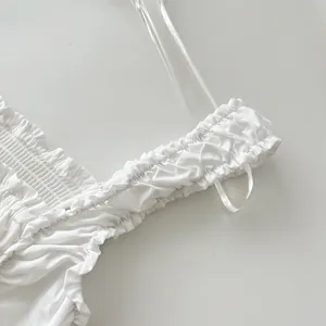 Primer plano del tirante elástico con volantes de un vestido largo blanco de verano