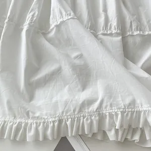 Primer plano del dobladillo con volantes blancos y tela plisada de un vestido de verano.