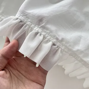 Primer plano detallado del borde de volantes de malla blanca en un vestido largo