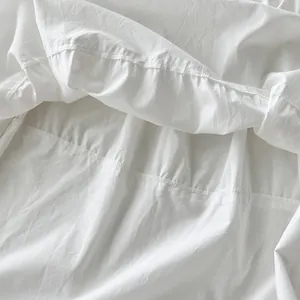 Primer plano del delicado borde con volantes y costuras del vestido largo blanco