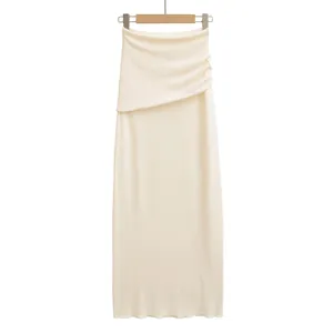 Vue complète d'une jupe longue en maille blanc cassé avec drapé asymétrique à la taille.