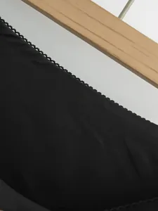 Détail en gros plan du tissu d'une jupe noire vintage avec bordure en dentelle fine