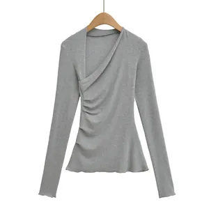 Détail d'un t-shirt gris à manches longues avec design asymétrique croisé sur le devant