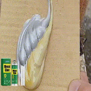 Dual-component JAKEHOE metal repair glue paste being applied to a flat wooden board