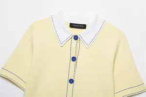 Gros plan d'un polo en tricot jaune avec col blanc et surpiqûres bleues