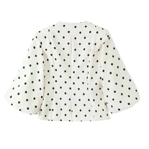 Vue arrière détaillée d'un blazer blanc vintage à pois noirs avec des manches évasées.