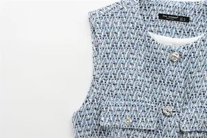 Vue détaillée du gilet en tweed bleu et blanc avec boutons argentés et texture
