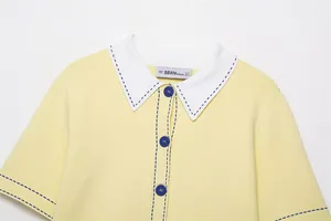 Close-up detail of a yellow knit polo cardigan with white collar and blue stitching