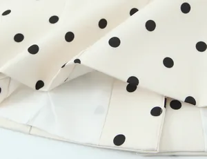 Gros plan d'un blazer à pois rétro montrant la texture du tissu et la doublure.