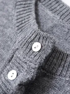 High-quality macro view of white buttons and ribbed collar on a grey knitted sweater.