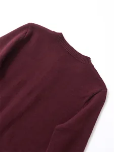 Detailed macro view of the ribbed round neckline on a soft burgundy knit sweater.
