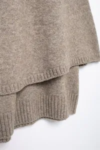 Nahaufnahme der gerippten Saumtextur einer braunen Strickjacke für Damen im Herbststil.