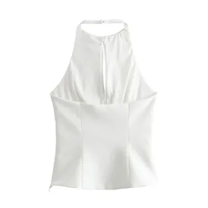 Detail of elegant white halter neck top with keyhole cutout and jewelry accent.