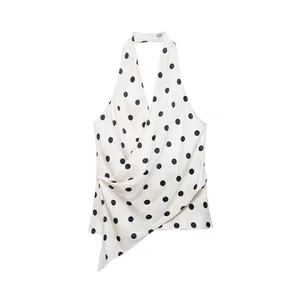 Detailed view of elegant white satin halter top featuring black polka dots and draped front