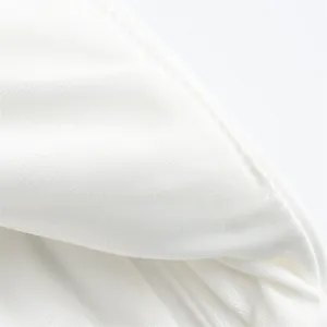 Close-up of high-quality white fabric and fine stitching on a halter neck top.