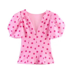 Detailansicht einer rosa gepunkteten Bluse mit Puffärmeln und V-Ausschnitt-Design