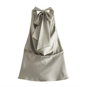 Detailansicht eines eleganten Neckholder-Tops aus Champagner-Satin mit großer Rückenschleife