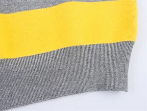 Close-up of yellow and grey striped knit sweater detail showing the ribbed hem texture.