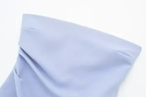 Vista detallada del top palabra de honor azul claro con textura plisada y costuras