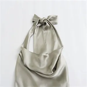 Nahaufnahme eines eleganten champagnerfarbenen Satin-Halterneck-Tops mit seidiger Textur