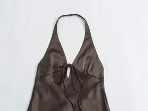 Detalle del vestido halter de satén marrón con escote en V y lazo delantero.