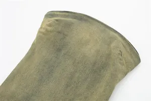Vista dettagliata della trama del tessuto denim lavato e del bordo della scollatura a fascia.