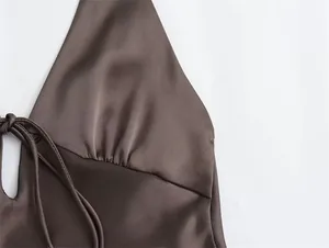 Detalle de vestido halter de satén marrón con busto fruncido y detalles de lazo