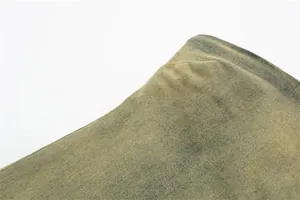 Dettaglio ravvicinato della trama e della tessitura del denim verde oliva lavato