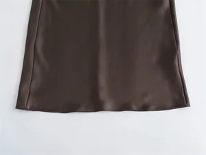 Detalle de la costura fina y el dobladillo liso de un vestido de satén de seda marrón