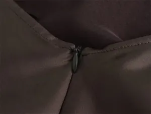 Primer plano de la cremallera invisible y la textura de la tela de satén de un vestido.