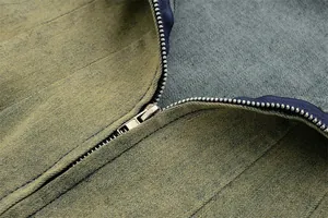 Dettaglio macro della cerniera in metallo e della trama vintage wash di un abito di jeans