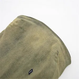 Dettaglio ravvicinato di un abito a fascia in denim lavato verde oliva con trama vintage