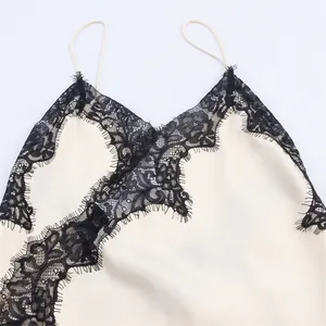Close-up of delicate black floral lace trim on a chic white spaghetti strap dress