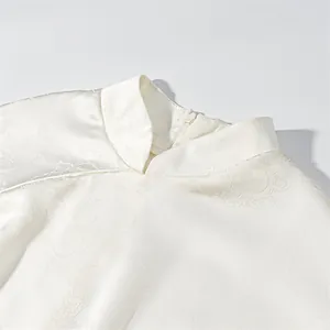 Close-up detail of the elegant white satin mandarin collar with intricate jacquard texture