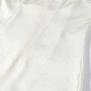 Detailed view of the intricate white floral jacquard fabric on a sleeveless bodycon dress