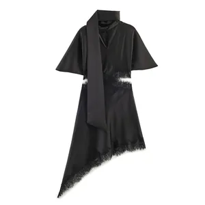 Detailed view of elegant black satin dress with lace trim and asymmetrical hemline