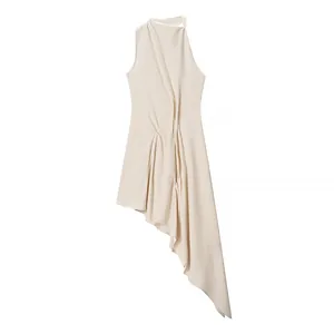 Detail showing the elegant asymmetric hem and draped knit texture of the beige maxi dress