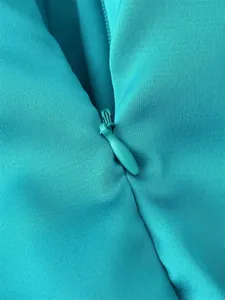 Macro view of high-quality matching invisible zipper on a stylish turquoise ruffle dress
