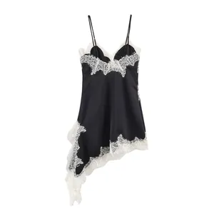 Detail of black satin slip dress with white floral lace and asymmetrical hemline